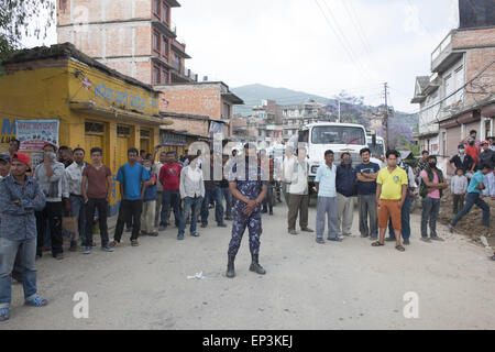 Le Népal. 13 mai, 2015. Un homme de la police monte la garde pendant Govt. népalais démolir un bâtiment détruit par le séisme de mardi dernier, ville Shankhu, près de Katmandou, Népal. Un séisme de magnitude 7,3 a tué au moins 37 personnes et semer la panique au Népal le mardi, la réduction de bâtiments déjà affaibli par un tremblement dévastateur il y a moins de trois semaines et déclenchant des glissements de terrain dans les vallées himalayennes près du mont Everest. Credit : Suvra Kanti Das/ZUMA/ZUMAPRESS.com/Alamy fil Live News Banque D'Images