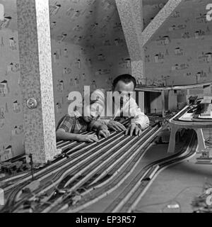 Ein Mann mit seinem Sohn suis bastelt Aufau (Modelleisenbahnanlage à Hamburg, Deutschland 1950er Jahre. Construction d'un père Banque D'Images