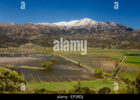 Dans le lac Stymfalia Corinthia, Grèce avec les montagnes enneigées en arrière-plan se reflétant dans les eaux du lac Banque D'Images