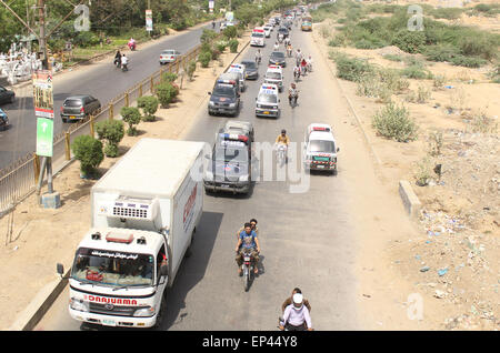 Grand convoi d'ambulance transportant des cadavres de victimes par balle en passant par la route de l'Université de Karachi le Mercredi, Mai 13, 2015. Six assaillants non identifiés circulant à moto a ouvert le feu sur un bus appartenant à la communauté Ismaili à Karachi's Safora Chowrangi salon, faisant au moins 43 morts et 24 blessés mercredi. Banque D'Images