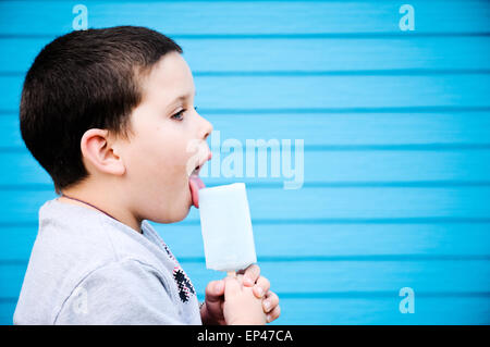 Vue latérale d'un garçon de lécher une glace lolly Banque D'Images