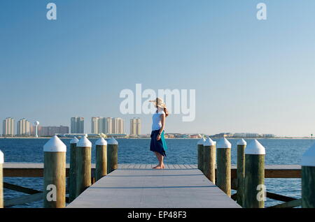 Femme au chapeau de soleil debout à la fin d'un quai, Florida, USA Banque D'Images