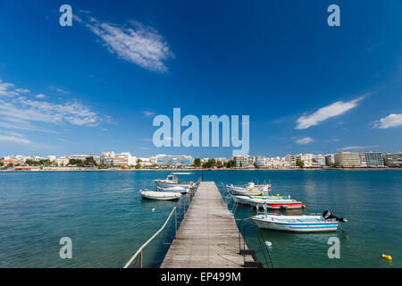 Bateaux à égalité à petit port en Chalkis, Eubée, Grèce contre un ciel nuageux avec les édifices de la ville en arrière-plan Banque D'Images