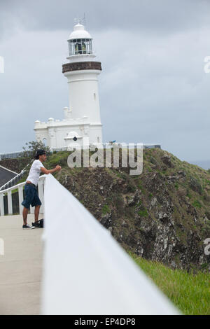 Un homme regarde vers la vue sur l'océan tout en prenant une pause de la randonnée jusqu'au phare de Byron Bay, en Australie. Banque D'Images