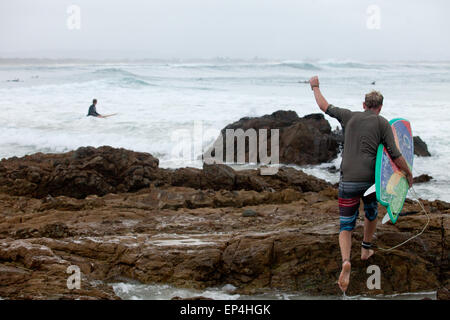 Étapes d'un surfer sur les rochers jusqu'à Byron Bay, en Australie. Banque D'Images