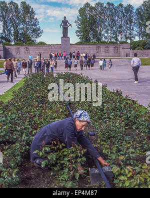 25 juin 1989 - Leningrad (St. Petersburg, Russie - une femme a tendance à le jardinier plantes le long du sentier où les visiteurs et les touristes se rassemblent devant une énorme statue en bronze de la patrie, décrite comme une femme en deuil, par les sculpteurs V.V. Isaeva et R.Ðš. Tauritt, qui domine les Piskaryovskoye Memorial Cemetery à Leningrad (aujourd'hui Saint-Pétersbourg) où un demi-million de personnes, dont 420 000 civils et 50 000 soldats sont enterrés dans le cimetière's 186 charniers après périr au cours de l'épique 900 jours de siège par les Nazis PENDANT LA SECONDE GUERRE MONDIALE. (Crédit Image : © Arnold Drapkin/Zuma sur le fil) Banque D'Images