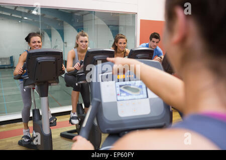 Motive les gens heureux à l'instructeur de spinning Banque D'Images