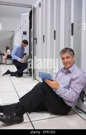 Technicien travaillant sur le plancher avec tablet pc Banque D'Images