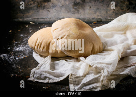 Deux de farine de pain de pita sur textile blanc, servi avec de la farine sur la table sombre Banque D'Images