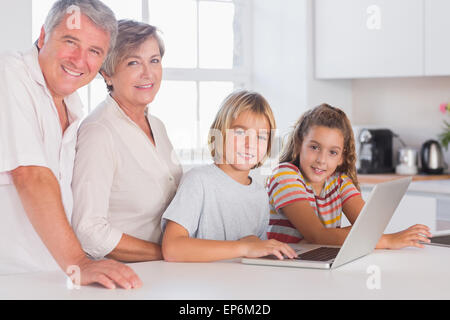 Les grands-parents et enfants regardant la caméra avec coffre à l'avant Banque D'Images