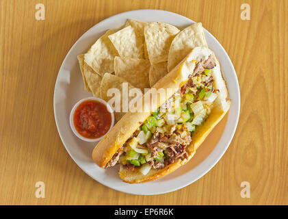 Philly Cheesesteak avec oignons en dés les poivrons et les champignons avec des croustilles et la salsa sur le côté Banque D'Images