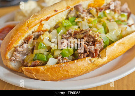 Philly Cheesesteak avec oignons en dés les poivrons et les champignons avec des croustilles et la salsa sur le côté Banque D'Images