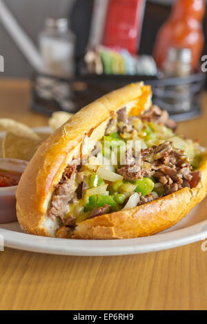 Philly Cheesesteak avec oignons en dés les poivrons et les champignons avec des croustilles et la salsa sur le côté Banque D'Images