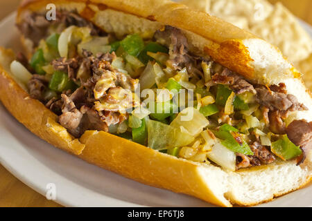 Philly Cheesesteak avec oignons en dés les poivrons et les champignons avec des croustilles et la salsa sur le côté Banque D'Images