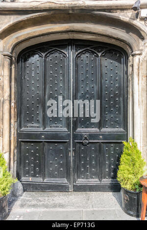 En bois médiévale parsemée double porte avec surround en pierre ancienne Banque D'Images