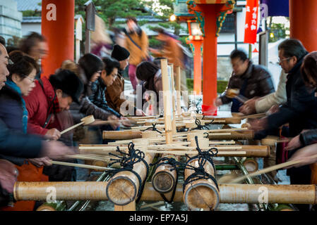 Les Japonais se purifier les mains et la bouche avec de l'eau avant d'entrer dans Sanctuaire Fushimi Inari le jour de l'An le 1er janvier 20 Banque D'Images