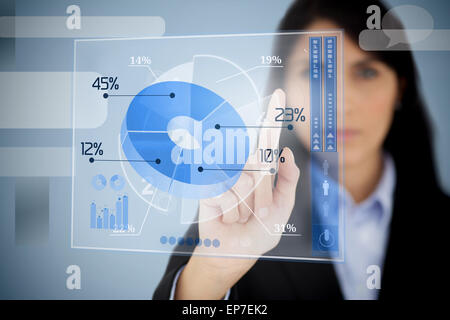 Serious businesswoman using blue pie chart interface Banque D'Images