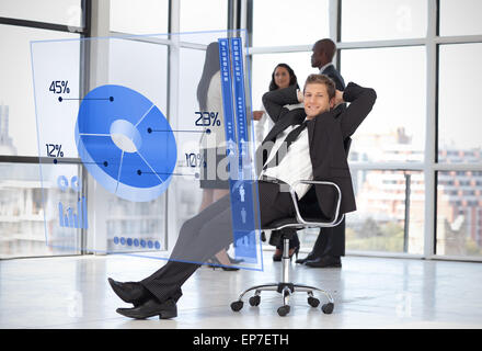 Confident businessman looking at blue pie chart interface Banque D'Images