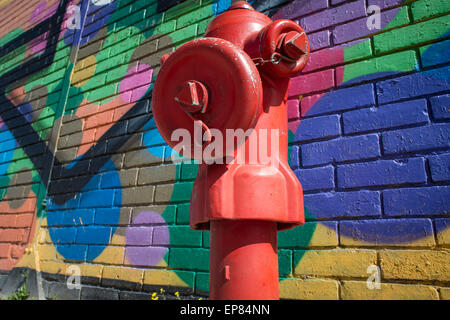 D'INCENDIE rouge contre un mur recouvert de graffitis Banque D'Images