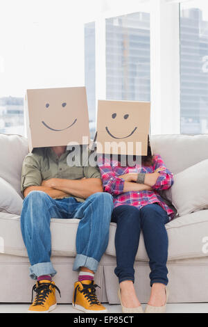 Funny workers with arms folded wearing boxes sur leurs têtes Banque D'Images