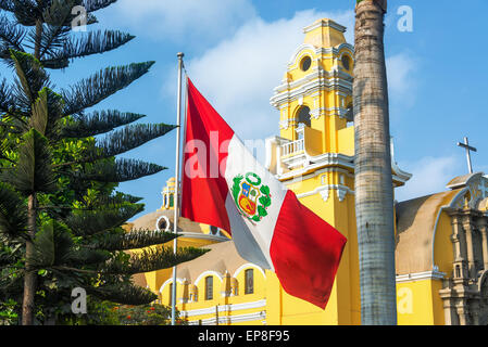 Drapeau péruvien jaune et église dans le quartier de Barranco à Lima, Pérou Banque D'Images