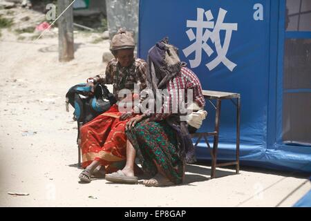 Le Népal, Dolakha. 15 mai, 2015. Les femmes s'asseoir à l'extérieur de la Chine a fait don de la tente à la zone touchée par le séisme, Dolakha dans environ 150 km de Katmandou, Népal, 15 mai 2015. Le nombre de morts dans un nouveau séisme puissant qui a secoué le Népal le mardi a grimpé à 117 et autour de 2, 760 autres blessés, la police du Népal a dit dans sa dernière mise à jour le Vendredi. Credit : Pratap Thapa/Xinhua/Alamy Live News Banque D'Images