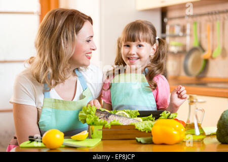 Maman heureuse et kid la cuisson des aliments dans la cuisine Banque D'Images