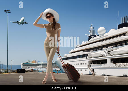 Le port de lunettes de soleil femme slim élégant et white hat standing près de port en bateau de croisière amarré Banque D'Images