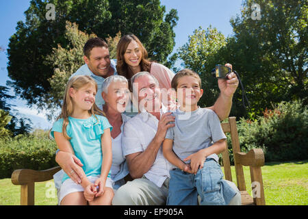 Assis sur un banc de la famille taking photo d'eux-mêmes Banque D'Images