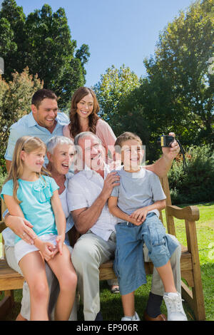 Multi generation family sitting on a bench taking photo d'eux-mêmes Banque D'Images