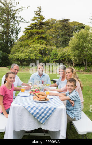 Multi generation family at picnic table de dîner à l'extérieur Banque D'Images