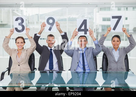 Smiling interview panel holding signs giving grade à leur demandeur Banque D'Images