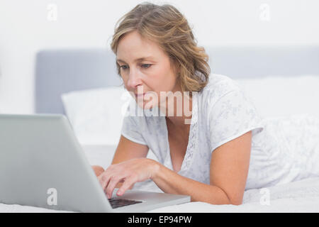Une blonde woman using laptop Banque D'Images