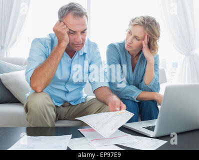 Young couple en utilisant leur ordinateur portable pour payer leurs factures Banque D'Images