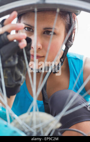 Femme à l'accent sur les rayons de roue de vélo Banque D'Images