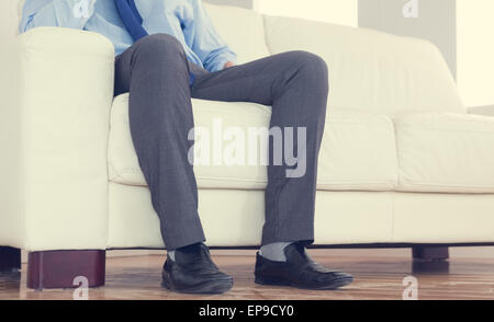 Partie basse de classy businessman sitting on cosy sofa Banque D'Images