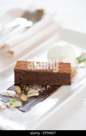 Brownice au chocolat servi avec de la crème glacée et le chocolat blanc. Banque D'Images