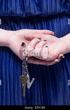 Close up of Lady's hands holding keys derrière son dos Banque D'Images