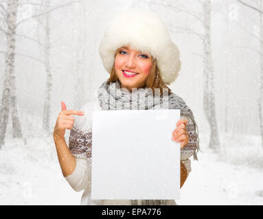 Jeune fille avec l'affiche vide à snowy winter forest Banque D'Images