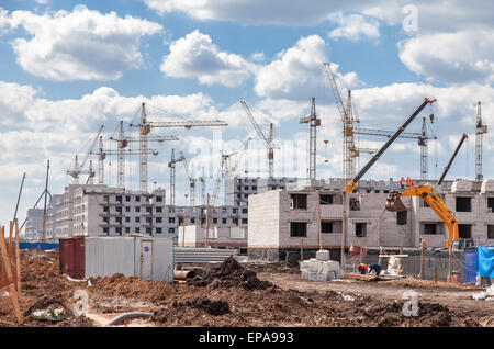 Les immeubles à appartements en construction avec des grues contre un fond de ciel bleu Banque D'Images