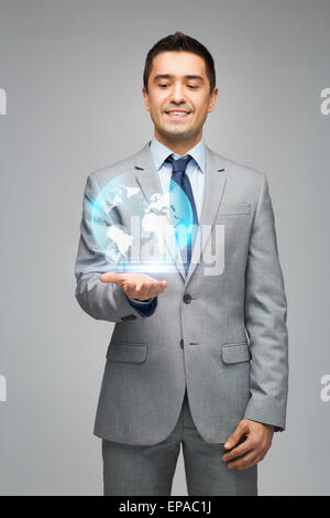 Happy businessman in suit montrant globe hologram Banque D'Images