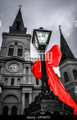 Big Red bows se suspendre à la lampe posts près de Cathédrale St Louis, Jackson Square dans le quartier français de New Orleans, LA Banque D'Images