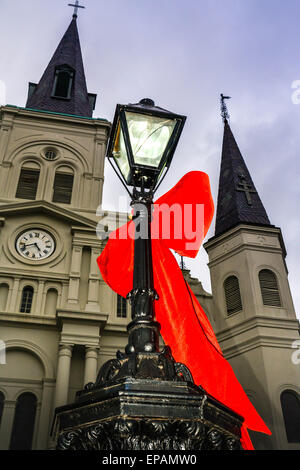 Big Red bows se suspendre à la lampe posts près de Cathédrale St Louis, Jackson Square dans le quartier français de New Orleans, LA Banque D'Images