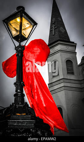 Big Red bows se suspendre à la lampe posts près de Cathédrale St Louis, Jackson Square dans le quartier français de New Orleans, LA Banque D'Images