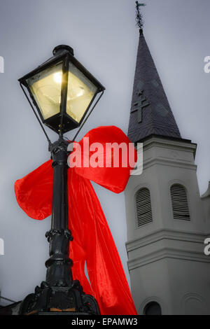 Big Red bows se suspendre à la lampe posts près de Cathédrale St Louis, Jackson Square dans le quartier français de New Orleans, LA Banque D'Images