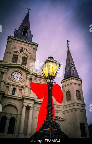 Big Red bows se suspendre à la lampe posts près de Cathédrale St Louis, Jackson Square dans le quartier français de New Orleans, LA Banque D'Images