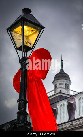 Big Red bows se suspendre à la lampe posts près de Louisiana State Museum, Jackson Square dans le quartier français de New Orleans, LA Banque D'Images