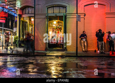 Des musiciens de rue en fin de soirée sur une pièce sombre Bourbon Street dans le quartier français sous la pluie à New Orleans, LA Banque D'Images