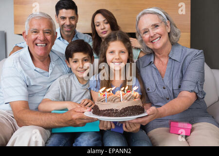 Portrait de famille élargie avec un gâteau dans la salle de séjour Banque D'Images