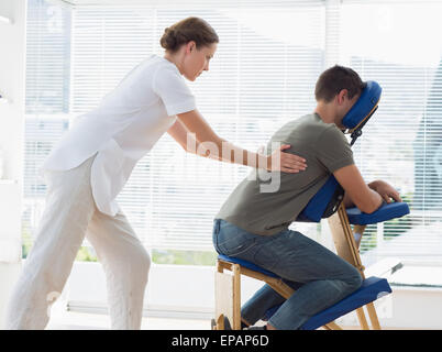 Man receiving massage dos de physiothérapeute Banque D'Images